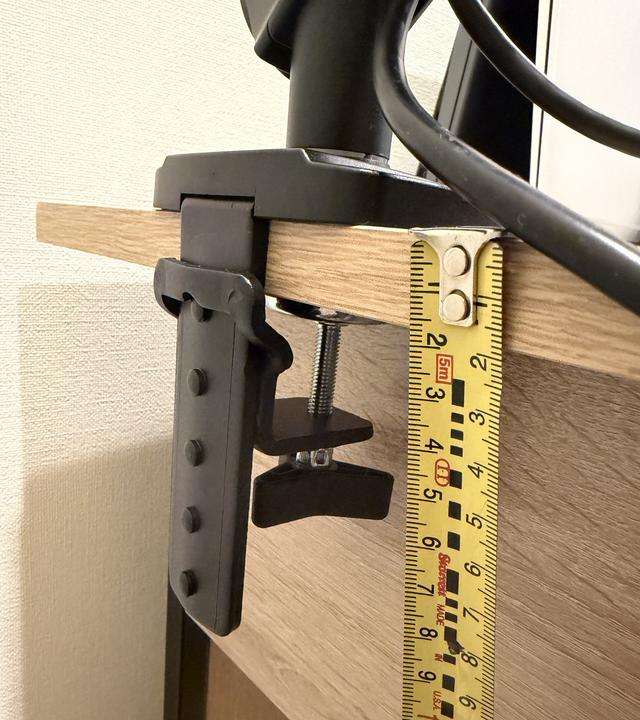 クランプで天板を挟んだ状態をメジャーで実測。天板厚約18mmでボルトに余裕あり