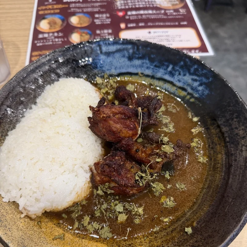 17 Proで撮ったカレー。手前の料理はシャープだが、奥のメニュー表は判読できないほどボケている