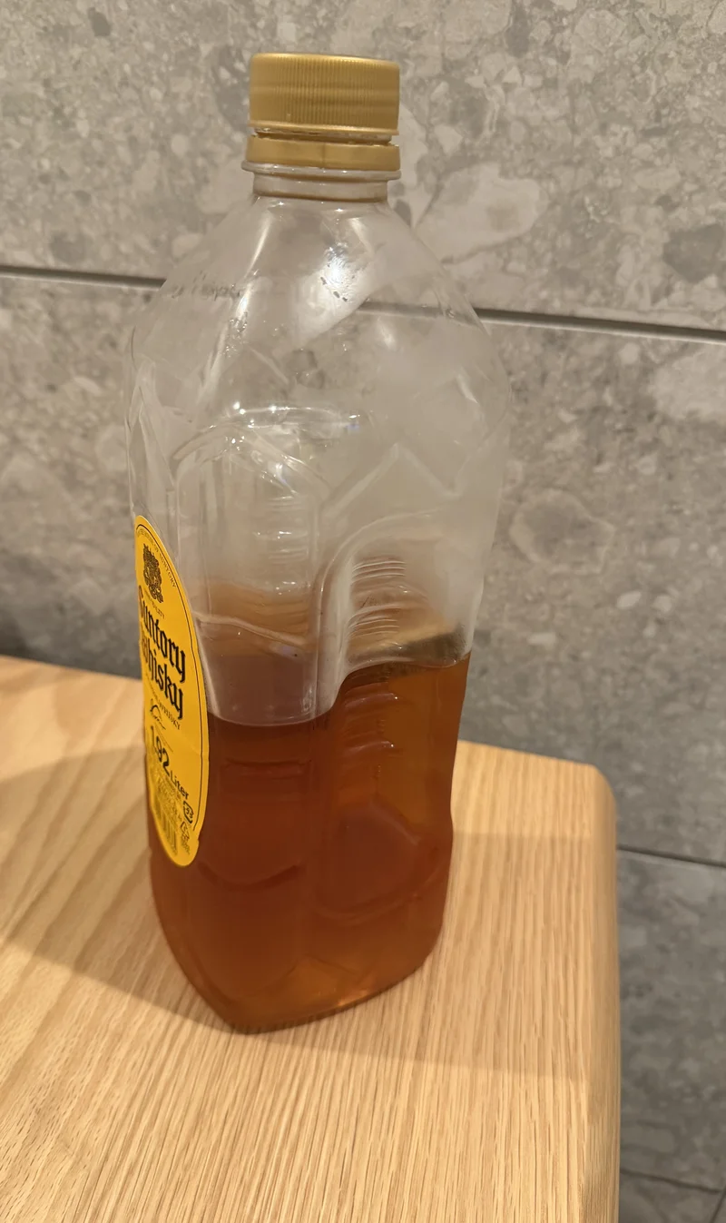 ミズナラスティックを入れた直後の角瓶1920mlペットボトル。半分ほどまで減った琥珀色の液体の中にスティックが立っている